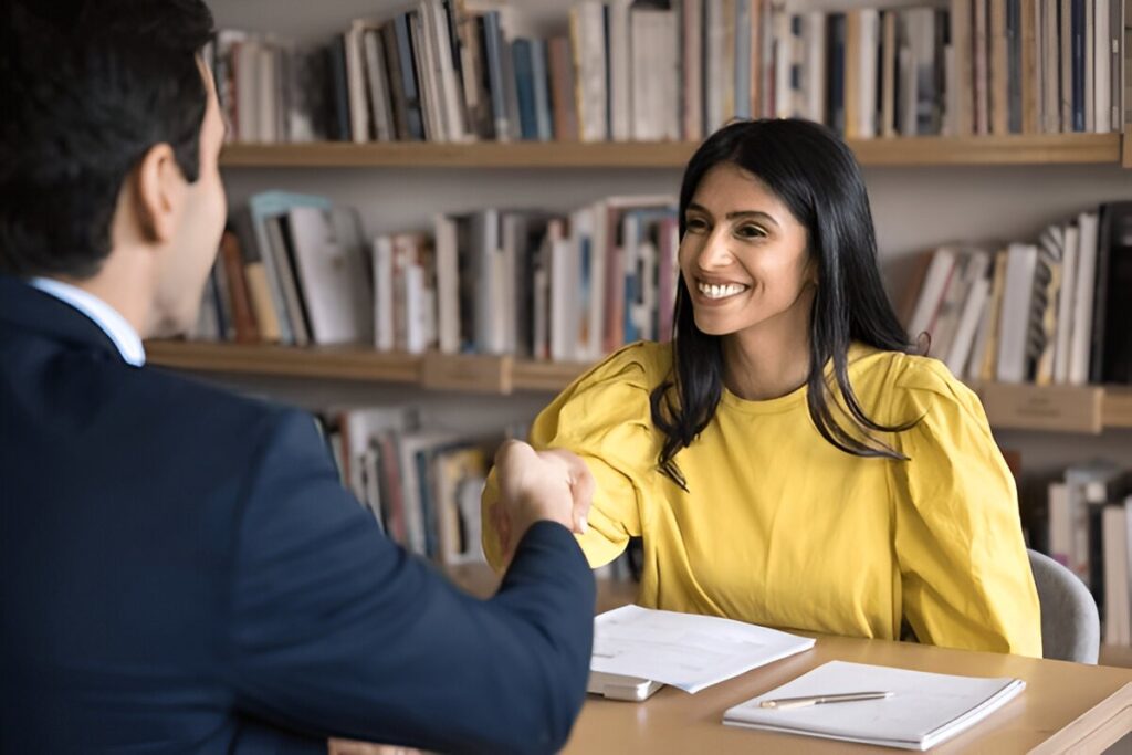 Smiling student shaking hands after successful part-time job interview